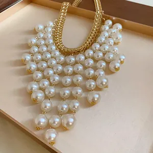 Close-up of elegant French style necklace with white pearl fringe and gold chain
