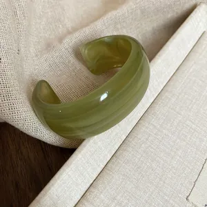 Elegant olive green acrylic cuff bracelet with marbled wave pattern