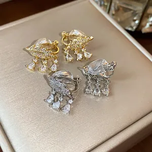 Dettaglio di orecchini a clip a foglia placcati in oro 18k con zirconi cubici