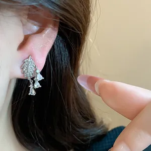 Primo piano di un orecchino a foglia placcato oro 18k con zirconi lucenti