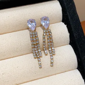 Close-up of water-drop zircon earrings with elegant rhinestone tassels in a jewelry box.