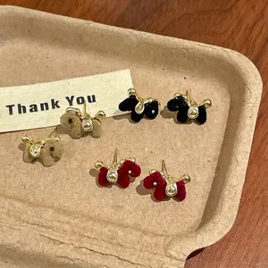 Detailed macro view of flocked horse stud earrings in black, red, and brown color options
