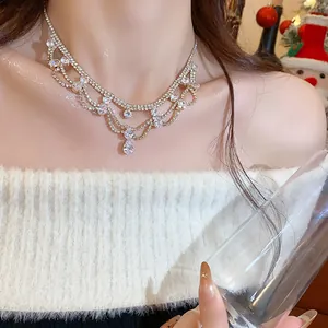 Close-up of elegant rhinestone fringe necklace with water drop pendant on model's neck.