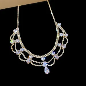 Close-up of elegant gold-toned necklace featuring shimmering teardrop rhinestones