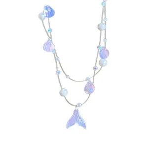 Dreamy iridescent mermaid necklace with pearl shell and fishtail pendants on white