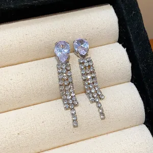 Detailed close-up of sparkling rhinestone water drop dangle earrings in jewelry box