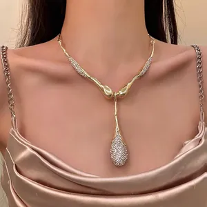 Elegante collana con pendente a goccia d'oro irregolare con strass scintillanti su modella.