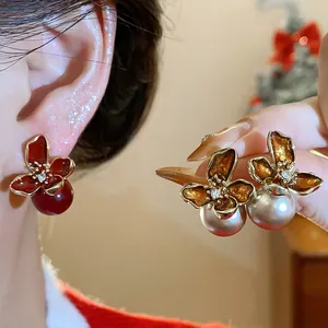 Vista detallada de los pendientes de flores de esmalte vintage con perlas y agujas de plata