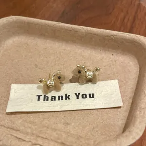 Detailed view of cute brown flocked pony stud earrings with golden metallic accents
