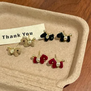 Detailed view of three pairs of flocked horse stud earrings in black, red, and brown.