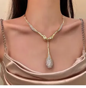 Vista dettagliata della collana di lusso dorata con pendente a goccia di strass