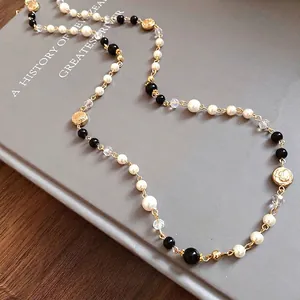 Elegant vintage long necklace with white pearls, black beads and golden floral motifs
