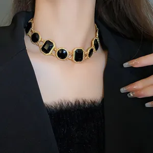 Close-up of vintage geometric crystal choker necklace in gold with black stones