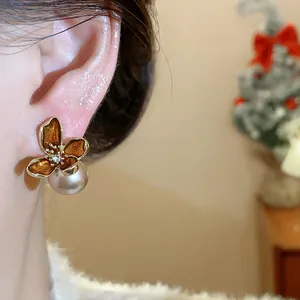 Primer plano detallado de estos pendientes de flores vintage con perlas y oro