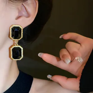 Close-up of vintage court-style earrings with black crystals and gold frames