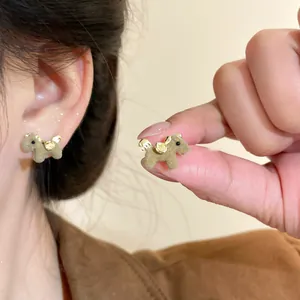 Detailed macro view of minimalist brown flocked horse earrings with gold plating