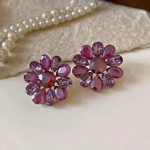 Detalle de cerca de pendientes de flores de cristal de estilo vintage en color púrpura.