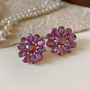 Detalle de pendientes de flores de cristal morado con diseño vintage y agujas de plata