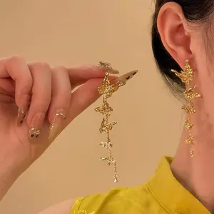 Detailansicht eleganter goldener Schmetterlings-Ohrhänger am Ohr