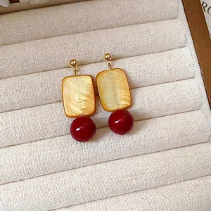 Elegant vintage earrings with square golden shell pendant and dark red glass bead decor