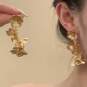 Detailansicht französischer Vintage-Ohrringe mit goldenen Schmetterlingen und Blumen
