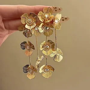 Nahaufnahme eleganter französischer Goldblumen-Ohrringe mit feinen Blütendetails