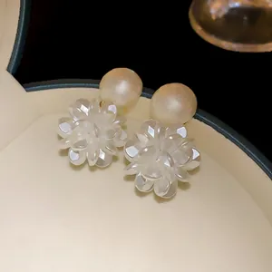 Primer plano de elegantes pendientes de flor de perlas con pétalos translúcidos