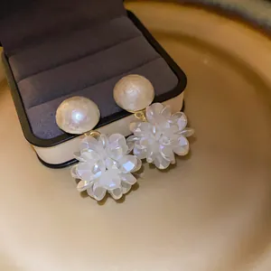 Primer plano detallado de pendientes de flores y perlas sobre un joyero de lujo en terciopelo