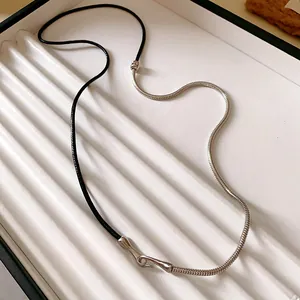 Detail view of punk style spliced necklace with black leather cord and silver snake chain