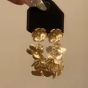 Nahaufnahme eleganter goldener Blumenohrringe im französischen Vintage-Stil