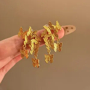 Elegante goldene Schmetterlings-Ohrhänger mit detaillierter Textur in der Nahaufnahme.