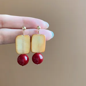 Detailed view showing square sugar-shaped resin and red glass bead retro drop earrings