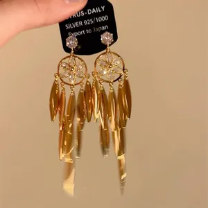 Detailansicht goldener Blumenohrringe mit Blattanhängern und S925-Materialkarte