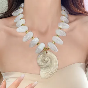Detailansicht einer klobigen Acrylkette mit Wassertropfenperlen und Muschelanhänger am Model