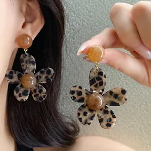 Retro resin flower earrings with vintage leopard print pattern shown worn on model ear