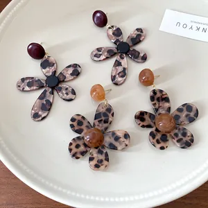 Close-up of vintage leopard print resin flower earrings displayed on a textured plate