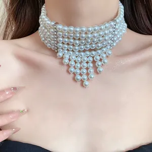 Close-up of elegant five-layer pearl choker with vintage tassel detail on model