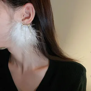 Close-up detail of elegant fairy white feather ear cuff with pearl and tassels