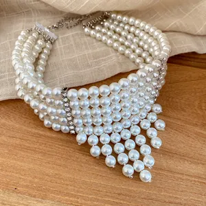 Detailed view of a five-layer vintage pearl fringe necklace with rhinestone spacers.