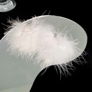 Detailed macro view of white feather ear cuff with pearls and silver tassels