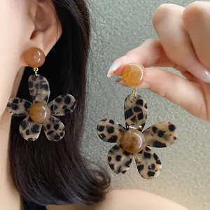 Close-up of retro leopard print flower earrings with marbled resin center details.