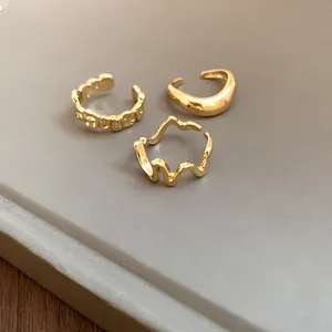 Detailed macro shot of three stylish irregular geometric gold open rings for women