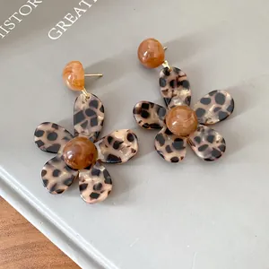 Close-up of vintage resin flower earrings with unique brown leopard print pattern detail
