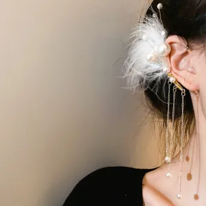 Primer plano de un elegante manguito de oreja con plumas blancas y borlas de perlas