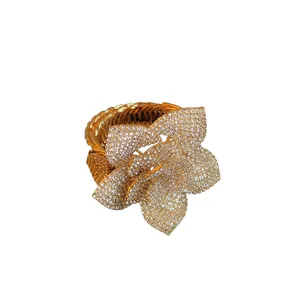 Elegant gold adjustable bracelet with sparkling 3D rhinestone flower design.