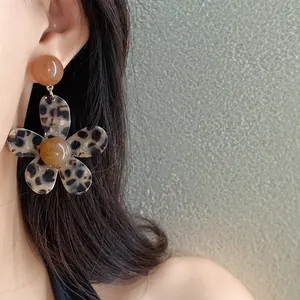Detail view of vintage leopard print resin flower earrings with amber bead accents.