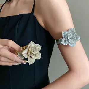 Detailed view of sparkling rhinestone 3D flower armbands available in gold and silver finishes