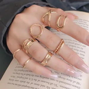 Detailed view of minimalist irregular geometric gold rings set worn on a model's hand
