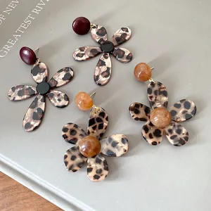 Close-up of retro resin flower earrings with trendy leopard print and silver needles.