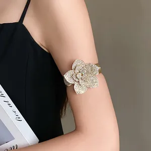 Detailed view of a sparkling crystal flower arm cuff jewelry worn on model's upper arm